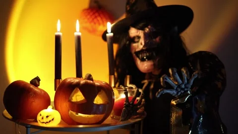 Halloween witch guards glowing pumpkins surrounded by eerie candlelight Video stock 346147691