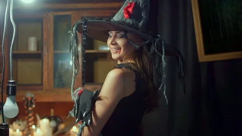 Halloween witch is looking at a spider on her shoulder. Video stock 100509849
