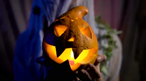 Halloween Witch with a magic Pumpkin in a dark room. Beautiful young woman in Stock Footage