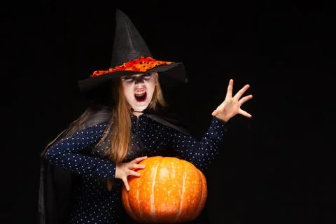 Halloween Witch with Pumpkin on black background Casts a spell with his hands Stock Photos