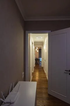 Hallway to dining nook with ring light and globe pendants, evening Stock Photos