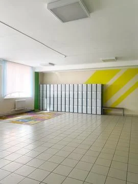 Hallway in an elementary school featuring storage lockers against a vibrant wall Stock Photos