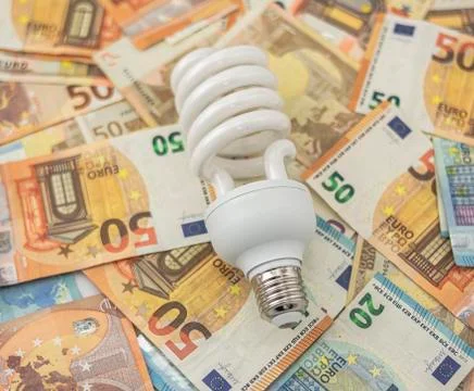 Halogen bulb on bed of twenty and fifty euro bills Stock Photos