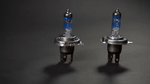 Halogen bulbs for car with silvery cap, panning on black background Stock Footage 161045147