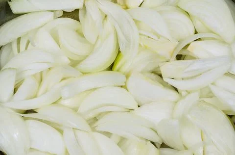 Halved and thinly sliced raw white onions. Close-up of chopped ripe onions. F Stock Photos