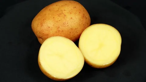 Halved and Whole Raw Potato Rotating on Black Background Stock Footage 343593935