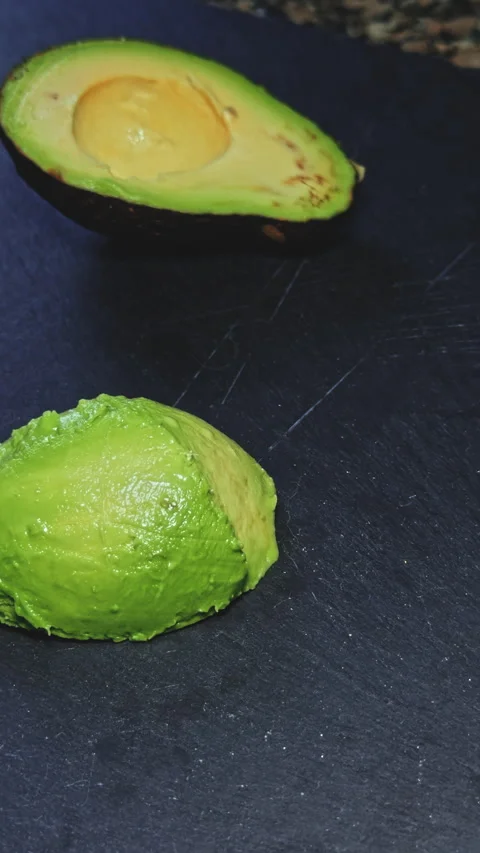 Halved avocado on a dark surface Stock Footage 277728413