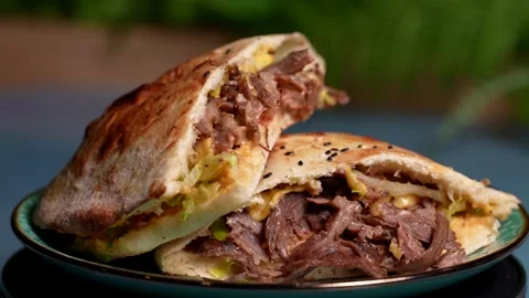 Halved beef and cheese flatbread reveals juicy meat, melted cheese  動画素材 310929622