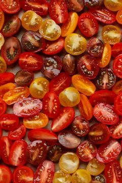 Halved cherry tomatoes pattern. mix of fresh and juicy vegetables colorful ba Stock Photos