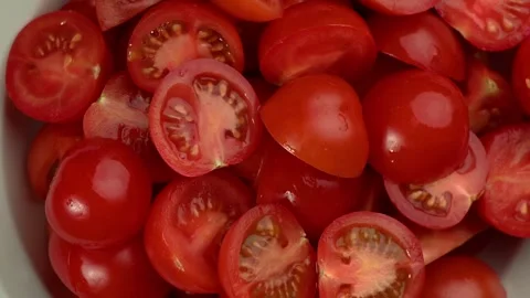 Halved cherry tomatoes rotating, juicy seeds, vibrant red flat lay Stock Footage 327465128