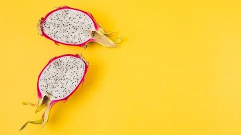 Halved dragon fruit yellow background Stock Photos