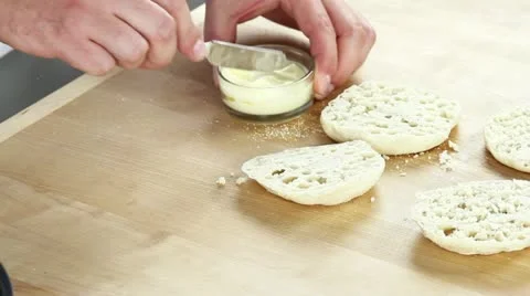 Halved English muffins being spread with butter Stock Footage 24671603