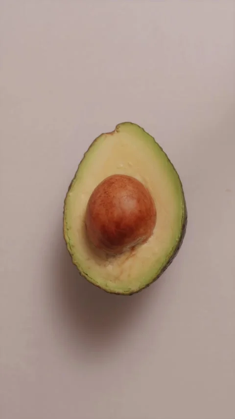 Halved fresh avocado fruit with seed on white background Stock Footage 337119167