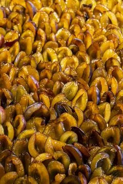 Halved fresh plums lined up on plum cake sheet cake Stock Photos