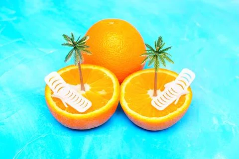 Halved Juicy Oranges with Tiny Lounge Chairs and Palm Trees 스톡 사진