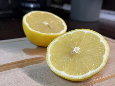 Halved Lemon on Cutting Board Facing Camera, Close-Up Stock Photos