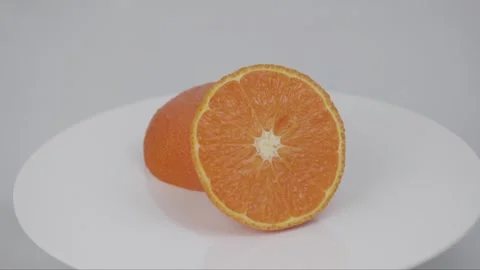 Halved Orange Rotating on a White Turntable, White Background Stock Footage 305317715