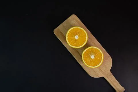 Halved orange on table on elegant black background. healthy food Stock Photos