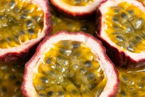 Halved passion fruit slices placed over juicy fruit pulp background Stock Photos