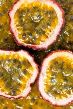 Halved passion fruit slices placed over juicy fruit pulp background Stock Photos