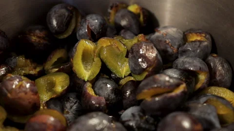 Halved pitted fresh plums falling into the pot Stock Footage 141295409