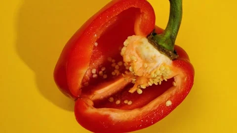 Halved Red Bell Pepper With Seeds on Yellow Background Top View Vidéo 292565007