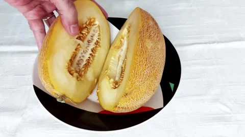 Halved Ripe Melon with Seeds on Bold Patterned Plate Stock-Footage 317073338
