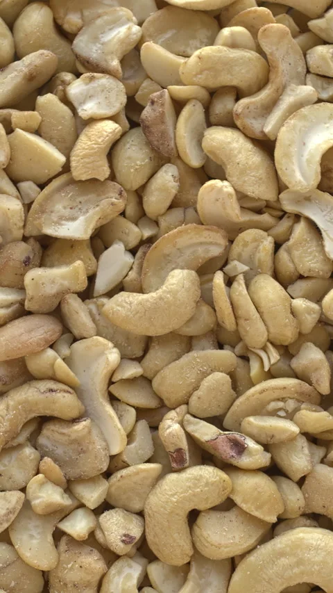 Halves of cashew nuts as background. Vertical video. Stock Footage 277987627