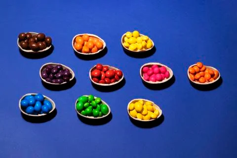 Halves of chocolate eggs with colored jelly on a blue background Stock Photos
