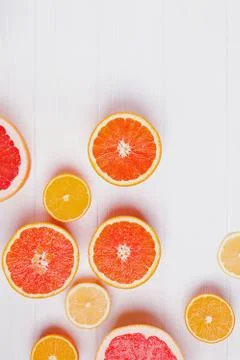 Halves of fresh orange and grapefruit citrus fruits on white wooden background Stockfoto's