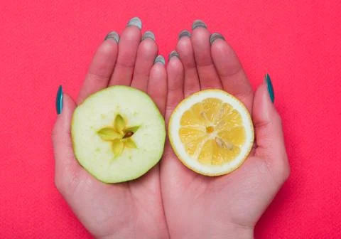 Halves of fruit lying on hands Stock Photos
