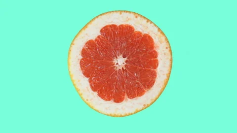 The halves of a grapefruit and an orange rotate in different directions against Stock Footage 119776608