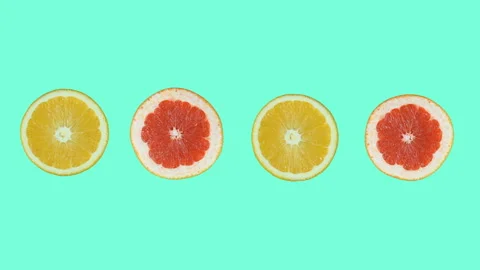 The halves of a grapefruit and an orange rotate in different directions against  Stock Footage 119815935