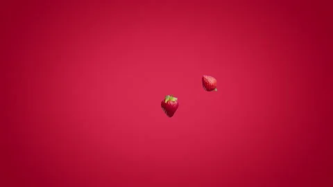 Halves of strawberries falling on a red background Stock Footage 178002638