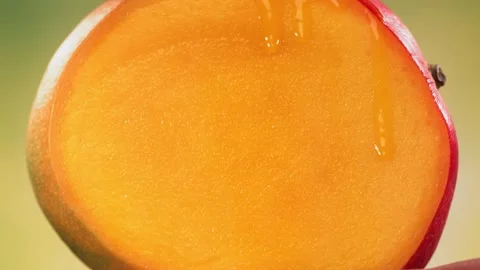 Halving Mango and Juice flows down the surface of rotating Halved King Mango Vidéo 228672438