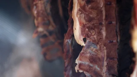 Ham and bacon hanging and drying in smokehouse on traditional way on blue smoke. Stock Footage 121482250