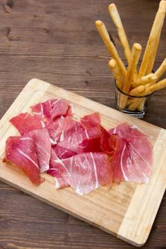 Ham and bread sticks on wooden table Stock Photos