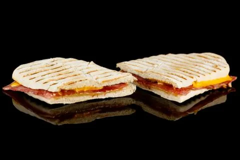 HAM AND CHEESE PANINI with reflection isolated on black background Stock Photos
