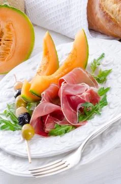 Ham with melon and olives Stock Photos