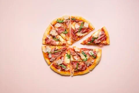 Ham pizza with arugula in equal slices. Sliced pizza prosciutto Stock Photos