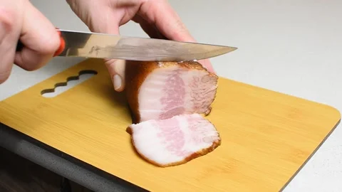 Ham Slicing on a Cutting Board in the Kitchen. Ham Slicing Video Stock Footage 303495296