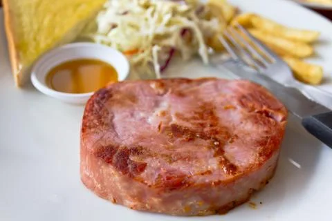 Ham steak with bread on a white dish Stock Photos