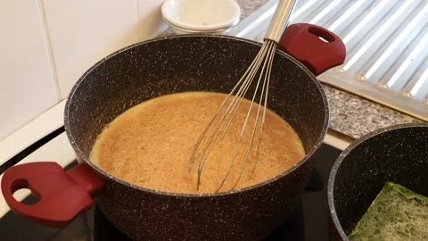 Hamburg, Germany 3.3.2023 Hand adding kitchen herbs to the sauce in a pan Stock Footage 235427724