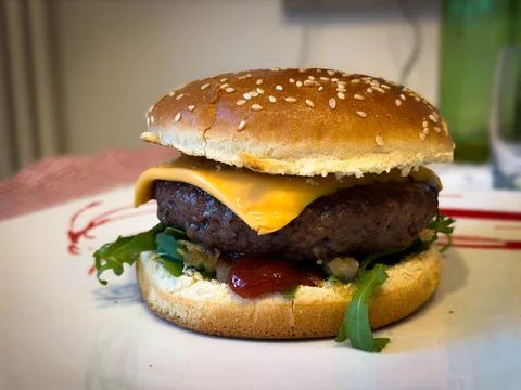Hamburger with beef, tomato, salad and cheese between two sesame breads Stock Photos