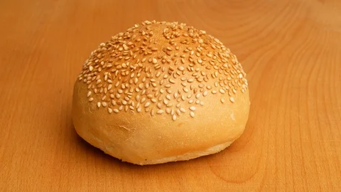 Hamburger buns cut into two pieces using a knife. Video stock 107620114