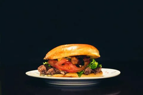 A hamburger with a dark background Stock Photos