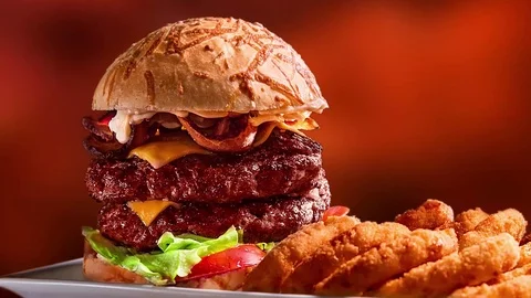 Hamburger double burger cheese bacon tomato lettuce onion rings with steam Stock Footage 116908672