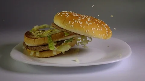 Hamburger Falling Down On Plate Slow Motion Fast Food Junk Food Concept. 動画素材 110986342