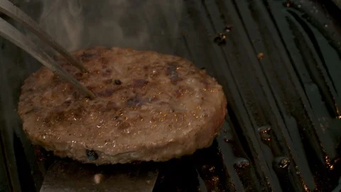 Hamburger flipped over while cooking on cast iron griddle Stock Footage 119512825