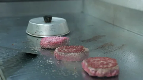 Hamburger flips on flat top grill Stock Footage 143326457